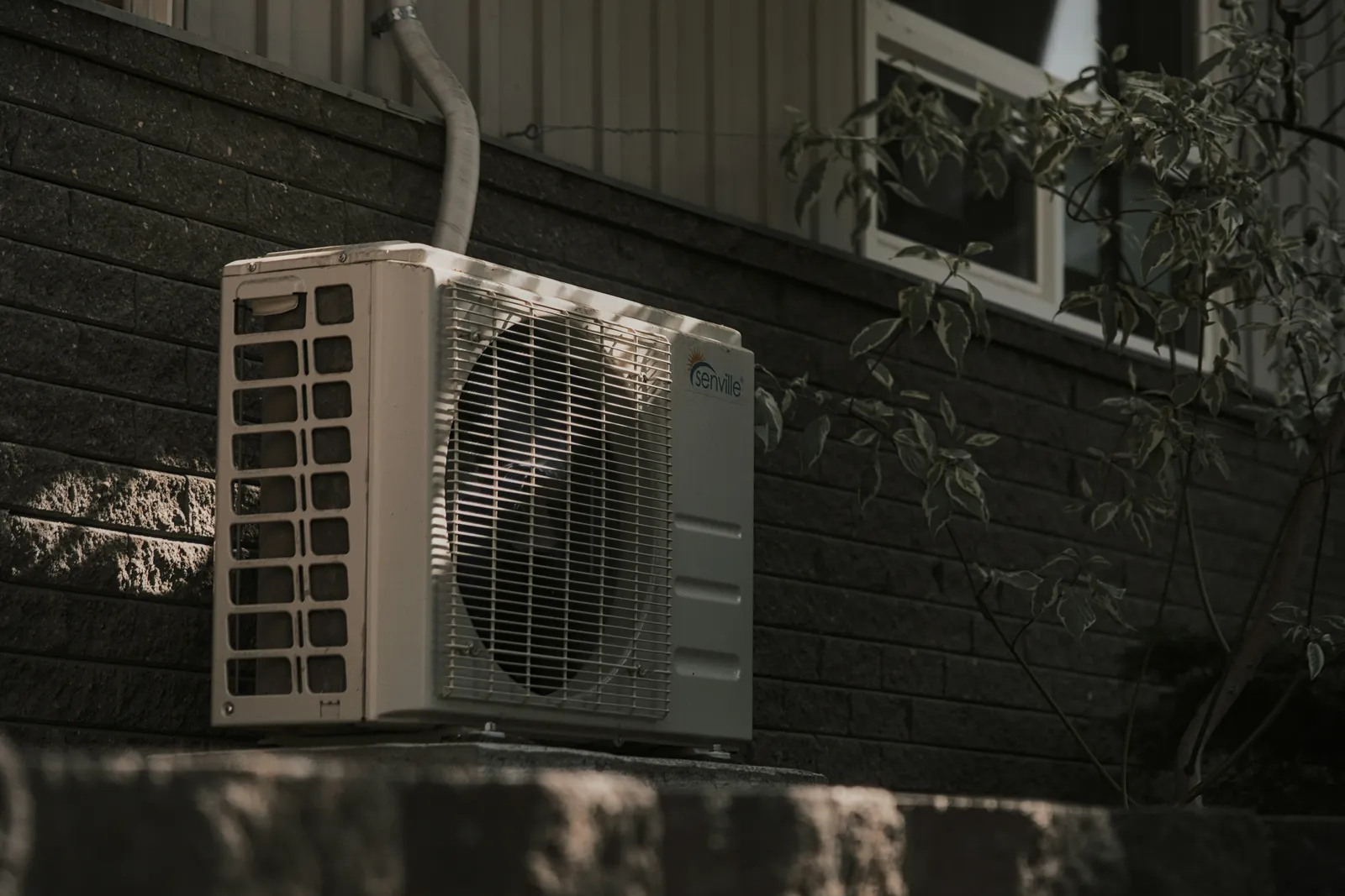 Outdoor heating and cooling unit installed beside a home
